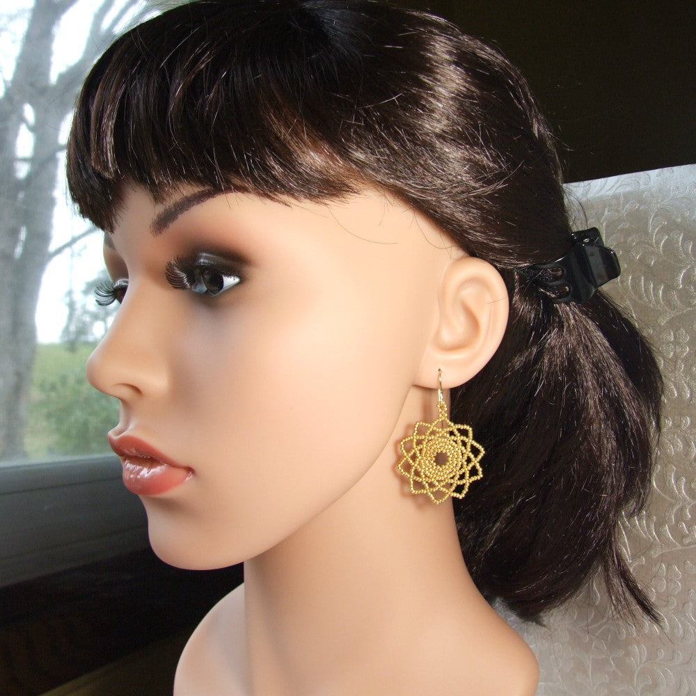 Mannequin head with dark hair and gold earrings.