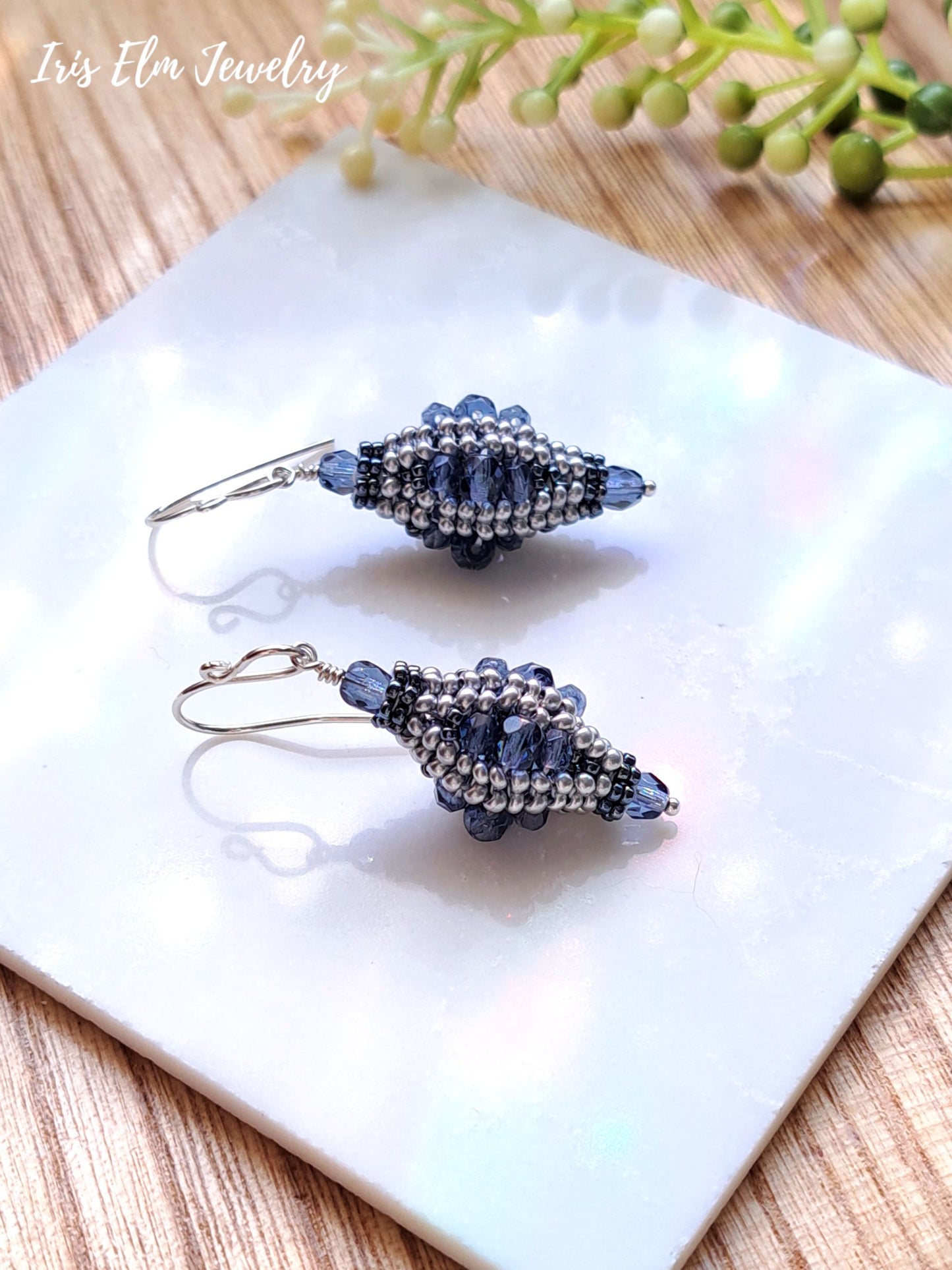 blue Czech glass beaded bead lantern earrings on white marble surface