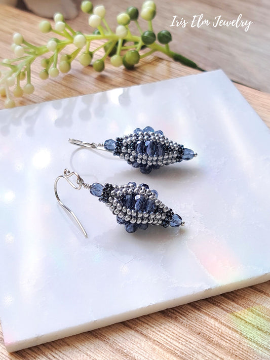 artisan beadwork handmade blue Czech glass lantern earrings on white marble surface with Iris Elm Jewelry branding