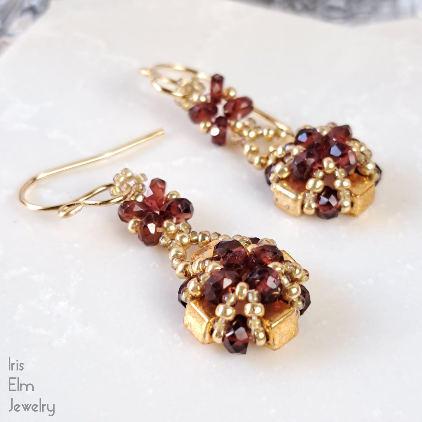 handmade Gold and red gemstone earrings with goldfilled earwires on a white surface with 'Iris Elm Jewelry' branding.
