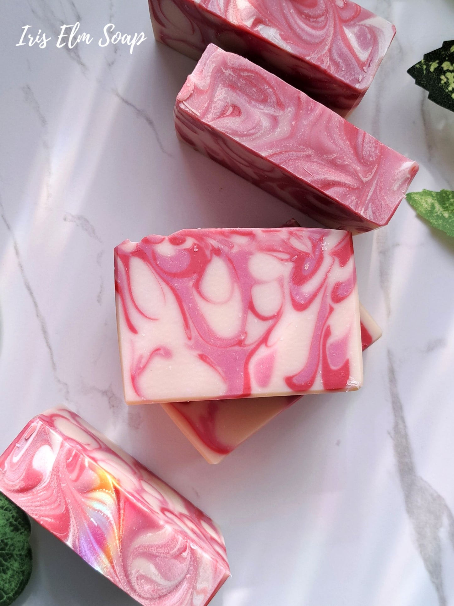 Pink and white marbled strawberry peach handmade soap bars on a marble surface with 'Iris Elm Soap' branding.