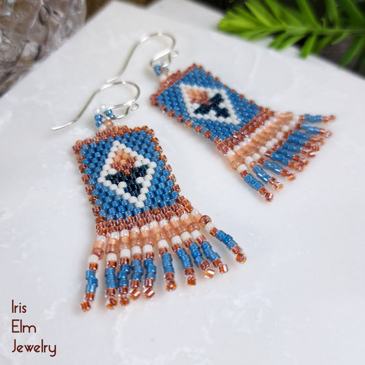 Beaded seed bead fringe earrings with tulip flower on a white surface, featuring the brand 'Iris Elm Jewelry'.