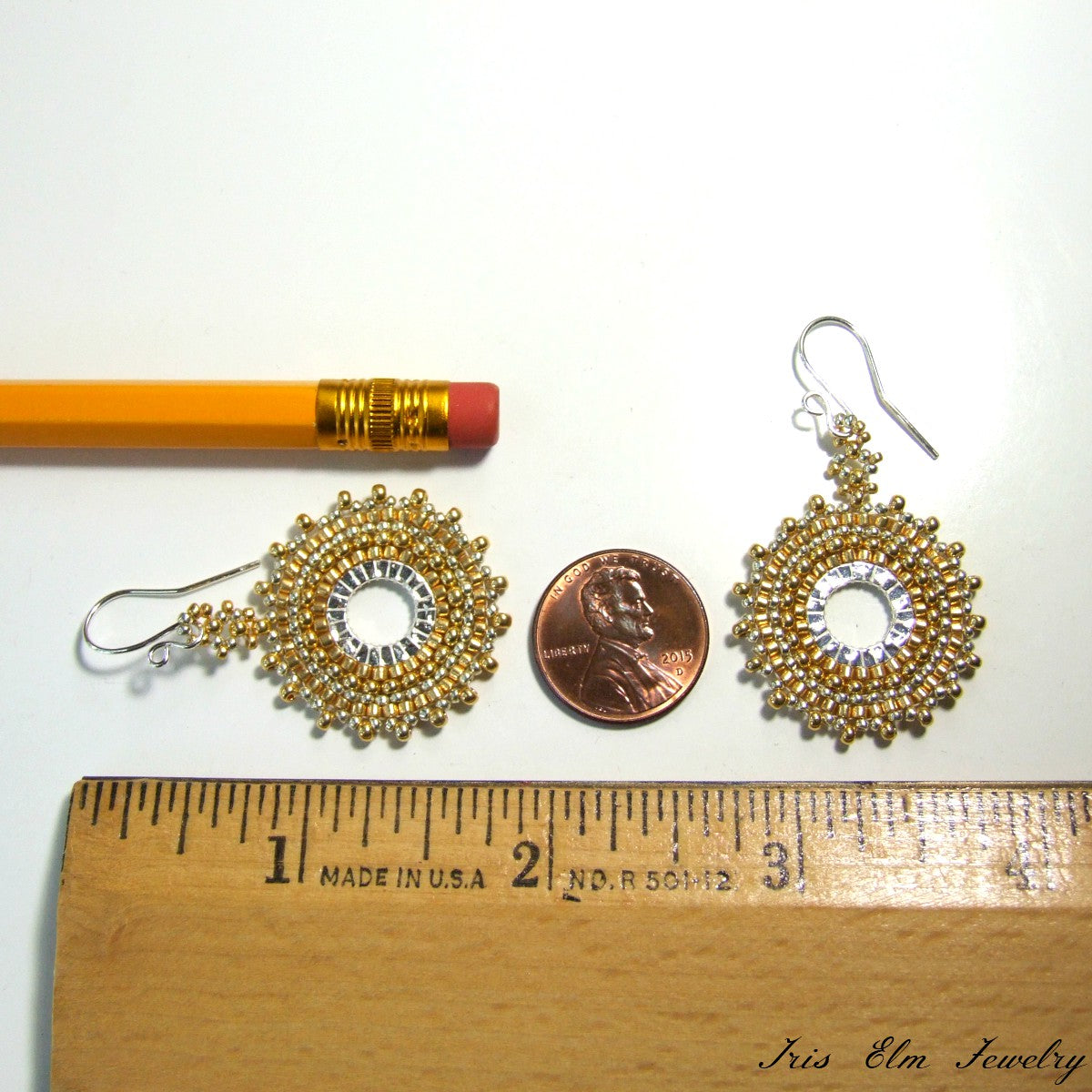 1 and 7/8 inches long gold and silver earrings next to a penny and a ruler for scale on a white background