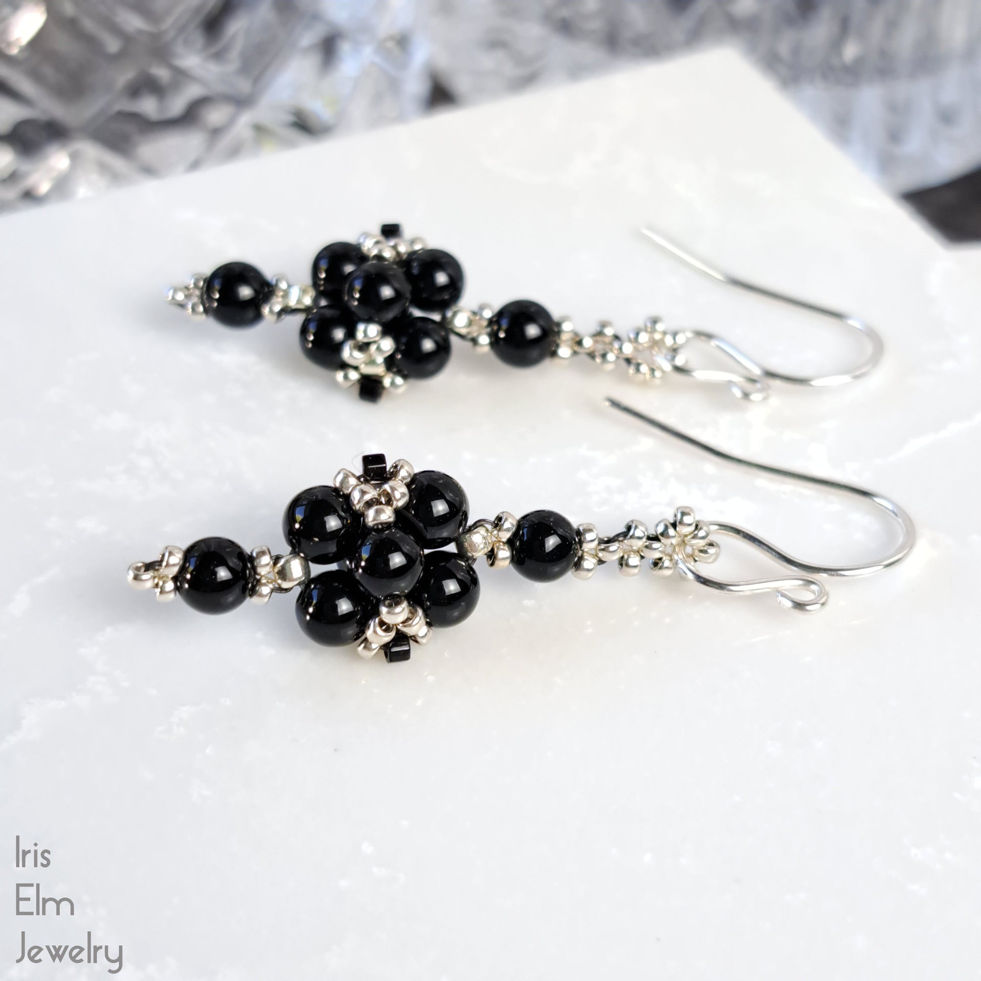 Black onyx small beaded earrings on a white surface with 'Iris Elm Jewelry' branding.