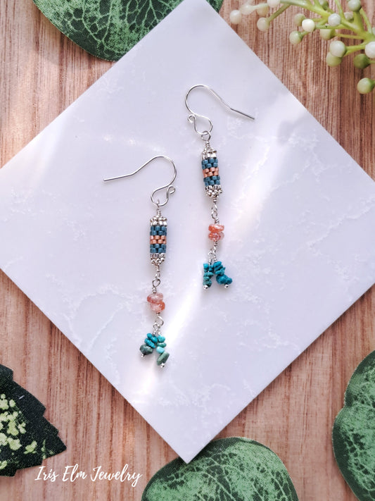 Pair of beaded sunstone and turquoise stone and seed bead sterling silver earrings on a white cloth with 'Iris Elm Jewelry' branding.