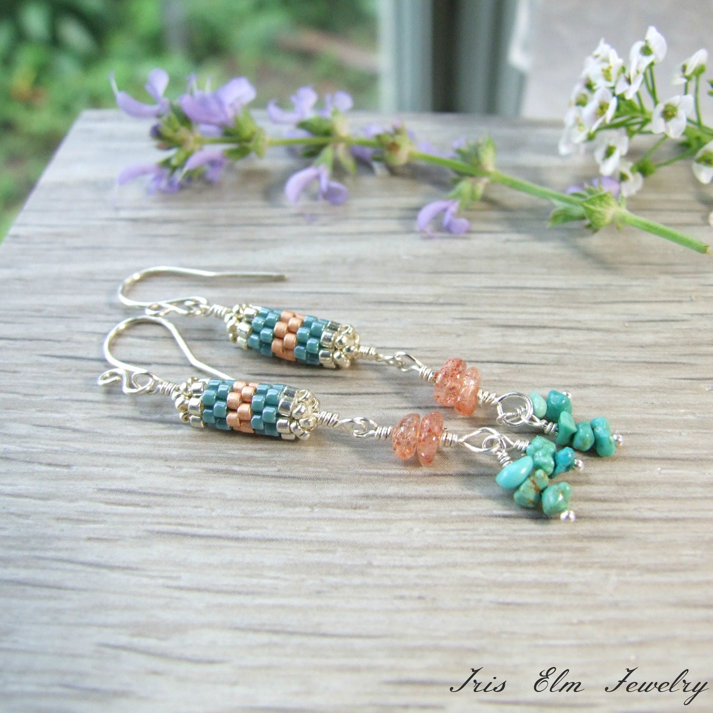 sterling silver glass seed bead and gemstone orange and turquoise Beaded earrings on a wooden surface with flowers in the background