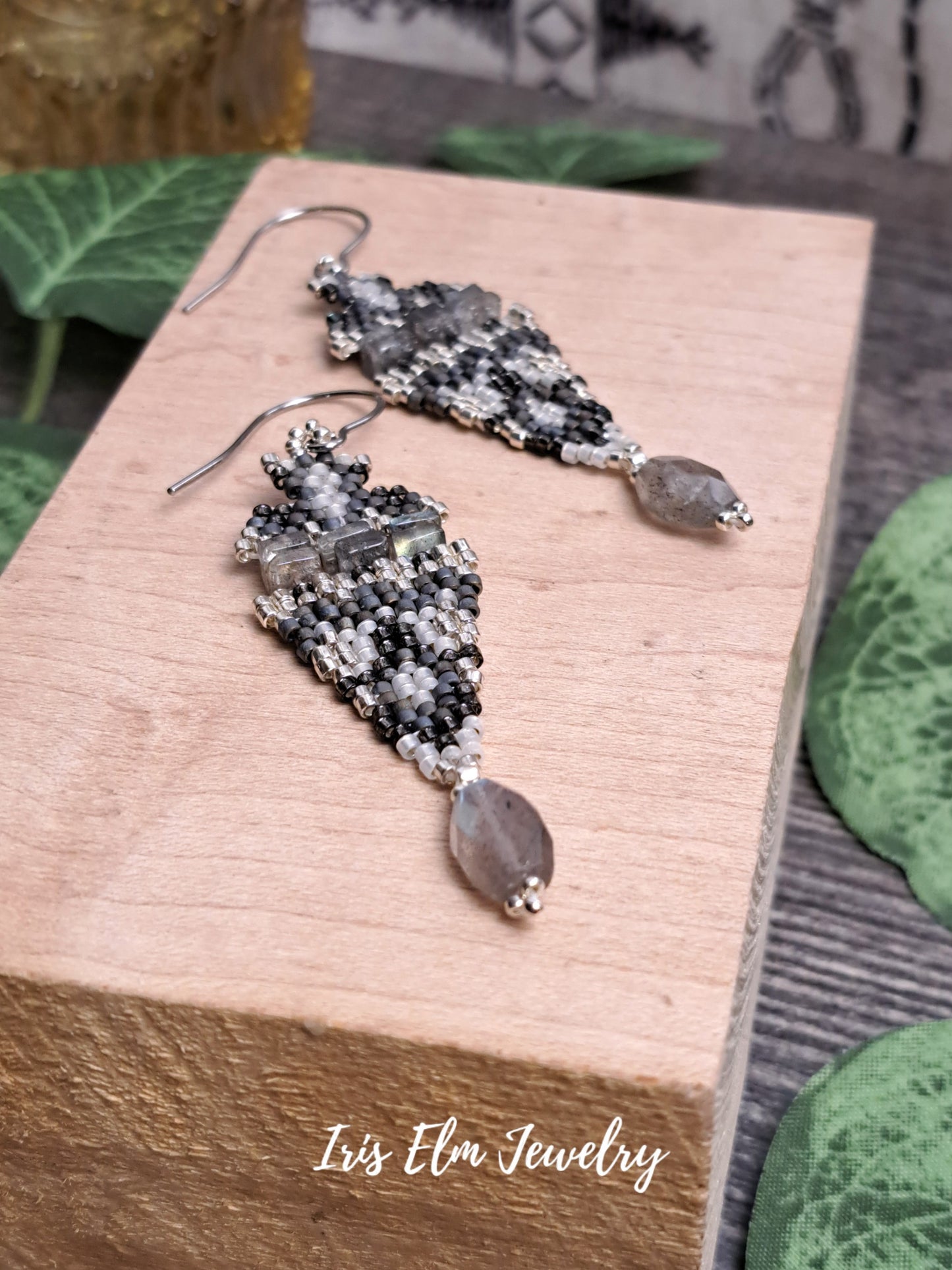 iridescent labradorite stone and seed bead boho beadwork earrings with grey, white, and silver beads on wooden block