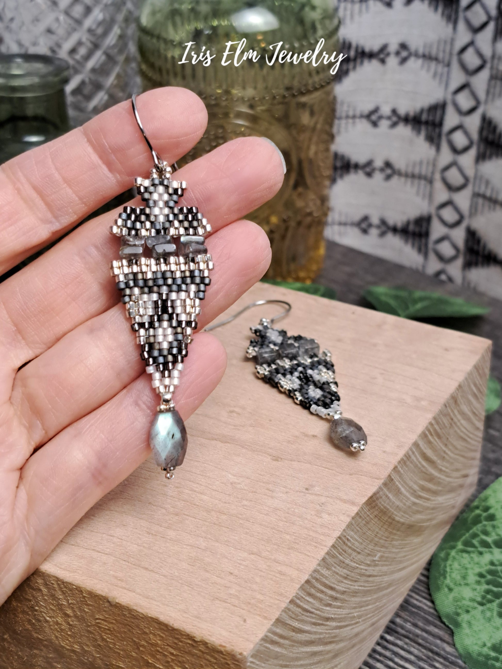 iridescent labradorite stone and seed bead boho beadwork earrings held in hand on wooden block