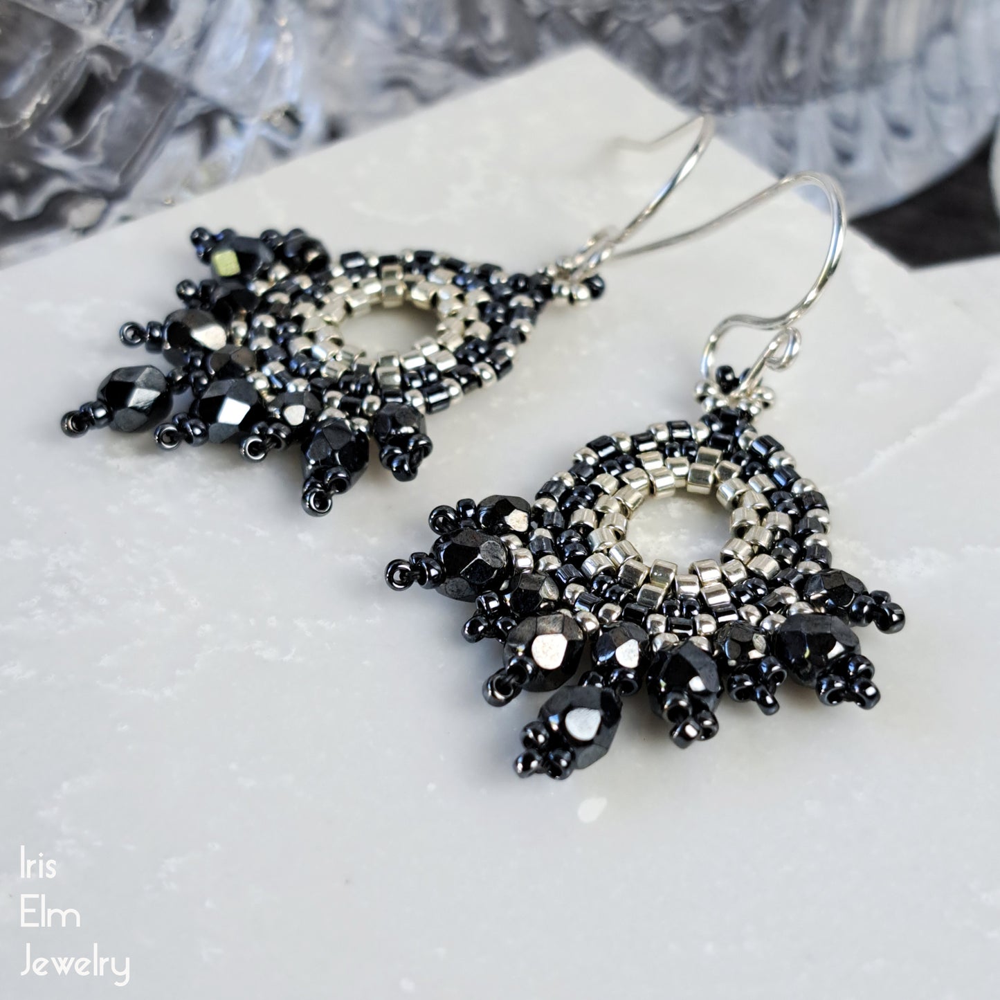 artisan handcrafted grey and silver beaded faceted glass earrings on a white surface with 'Iris Elm Jewelry' branding