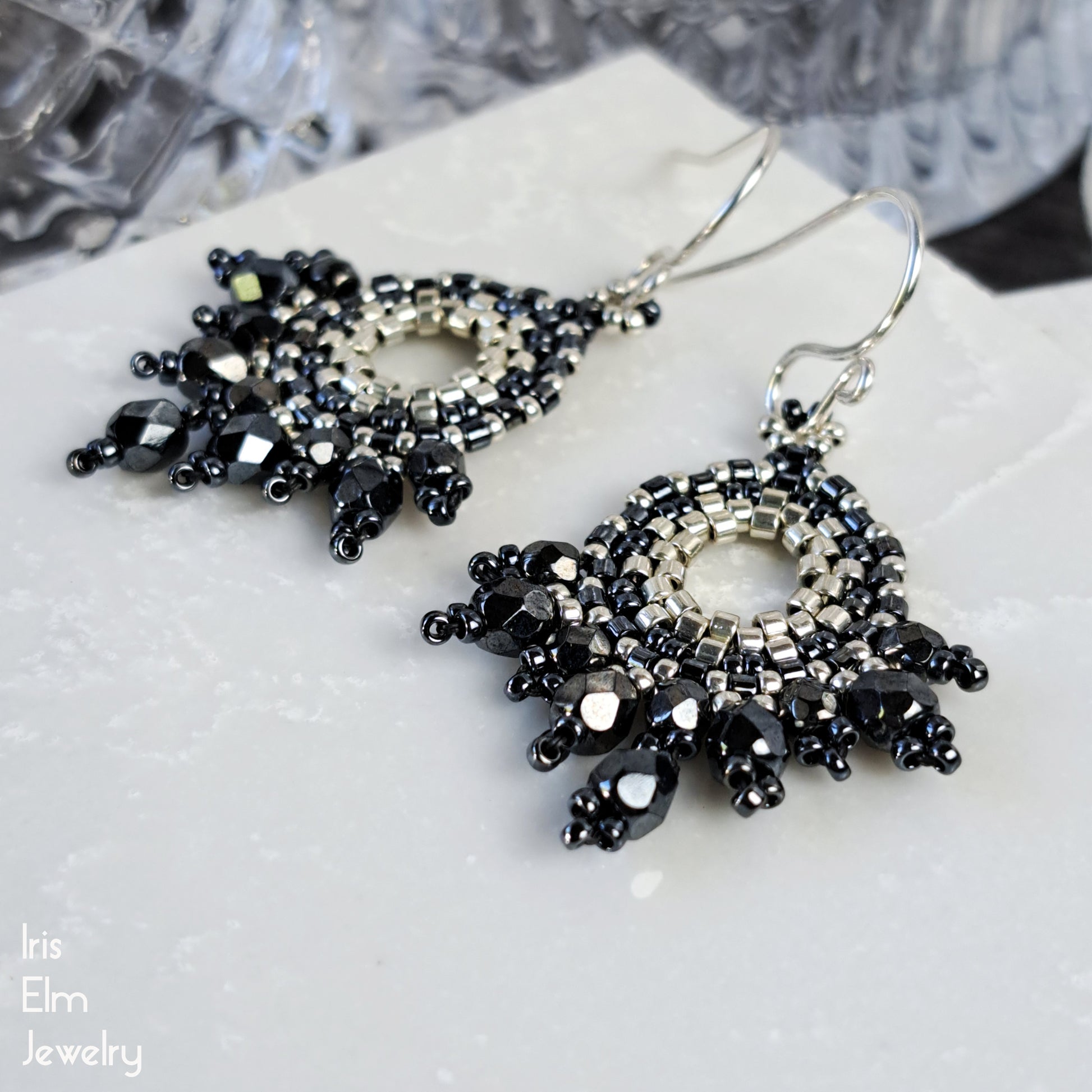artisan handcrafted grey and silver beaded faceted glass earrings on a white surface with 'Iris Elm Jewelry' branding