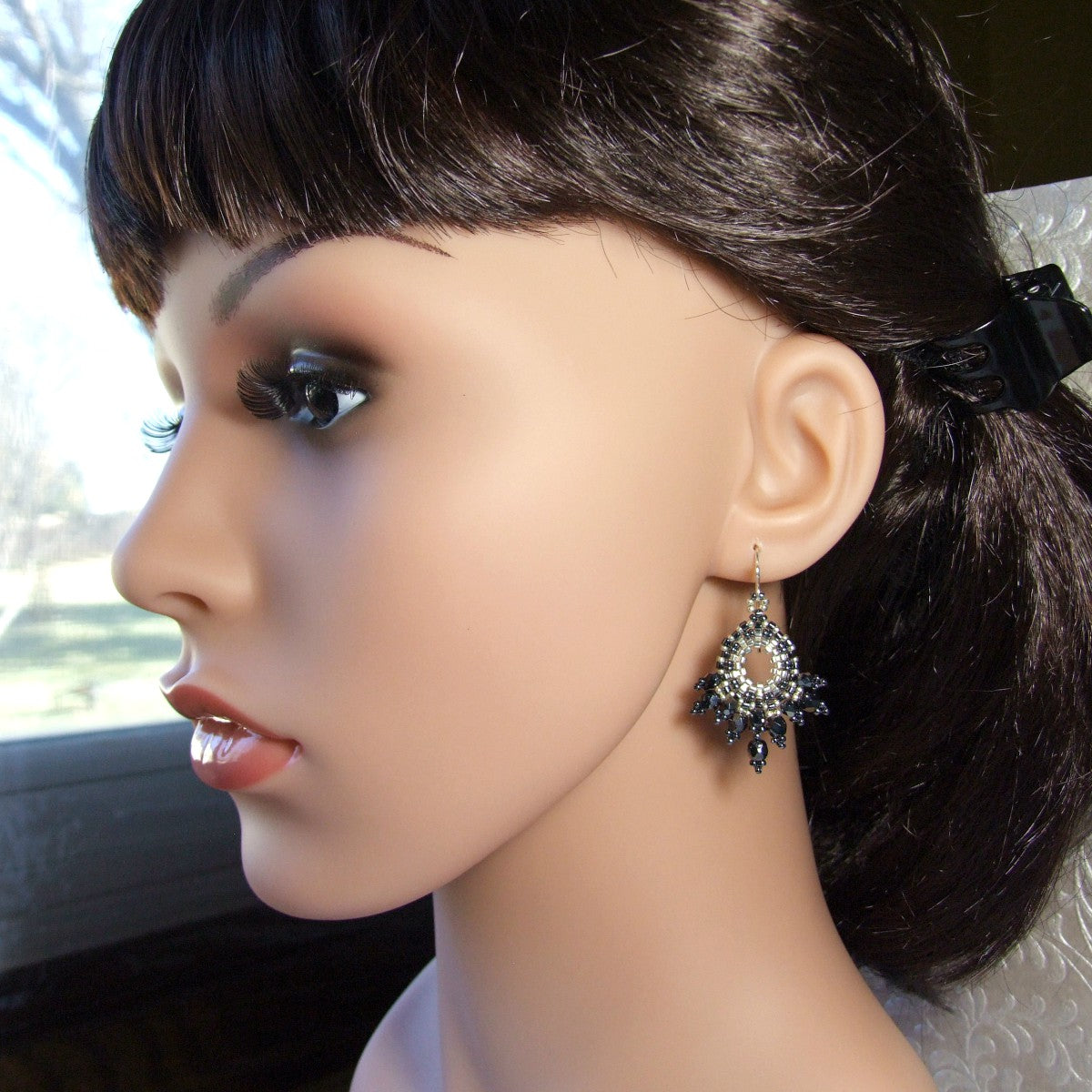 Mannequin head with dark hair and a decorative czech glass fan earring