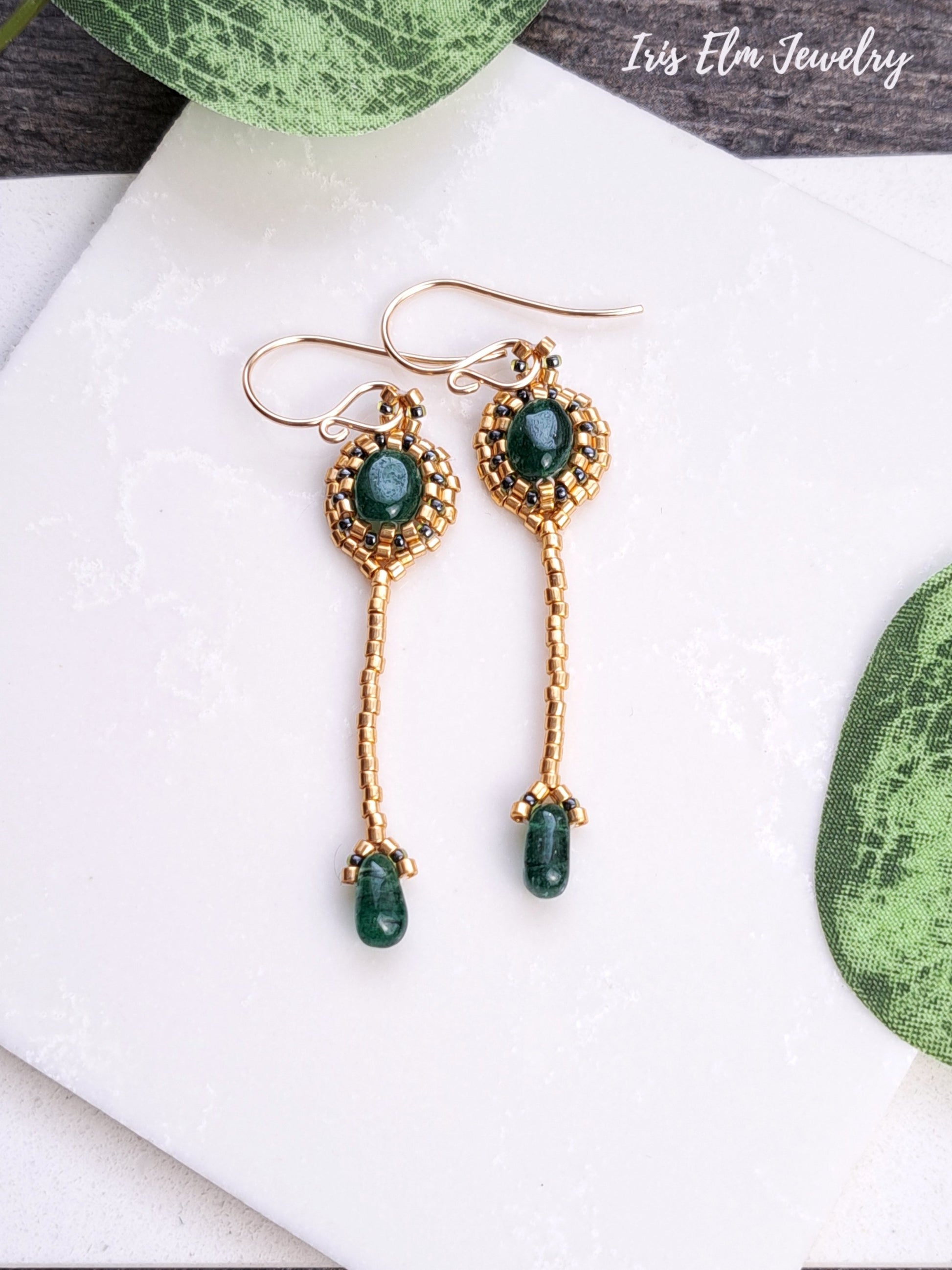 handmade art deco Gold earrings with green aventurine gemstones on a white surface, branded 'Iris Ella Jewelry'.
