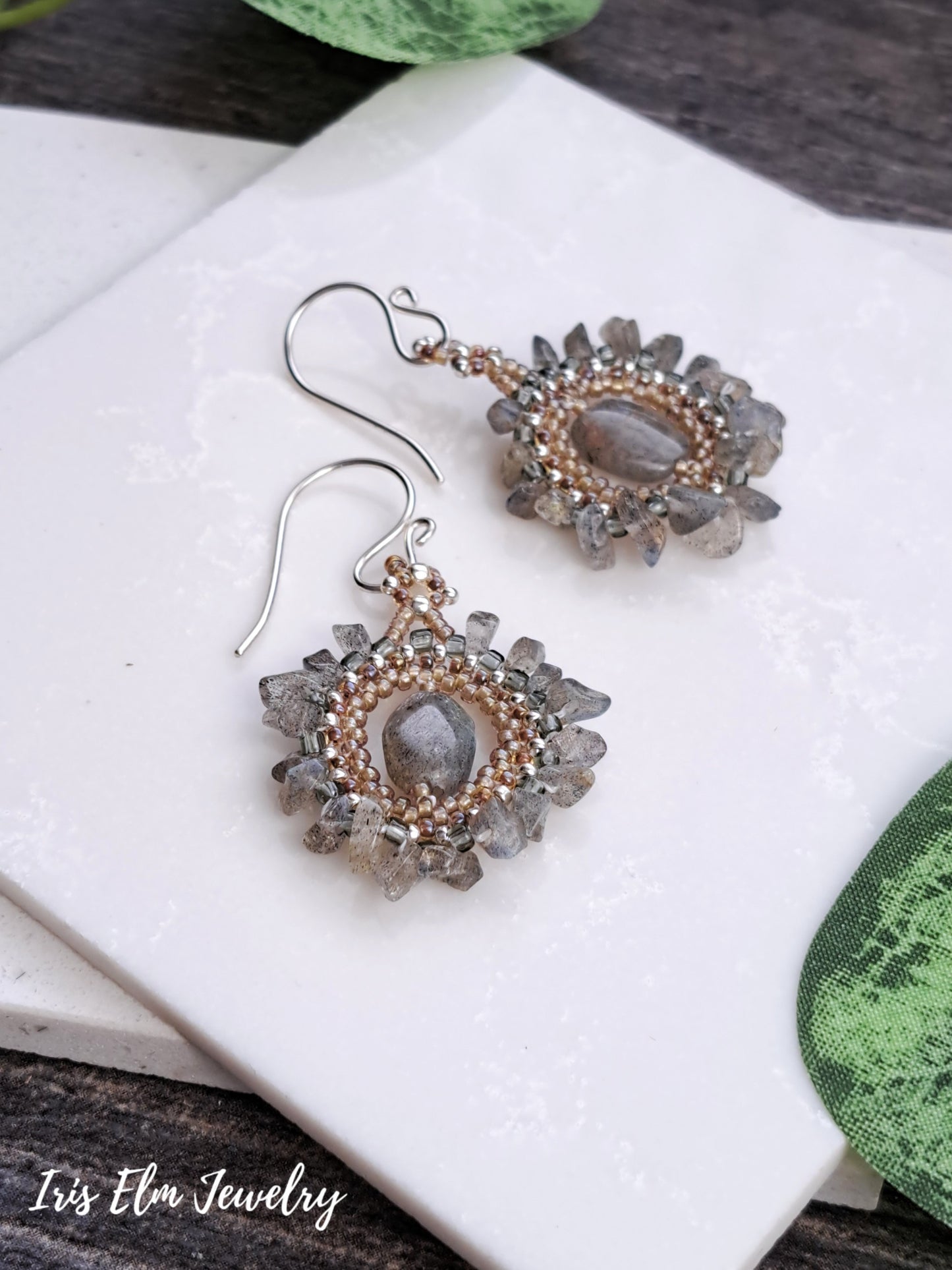Pair of bohemian labradorite beadwork handmade earrings with gemstone centers on a white surface.