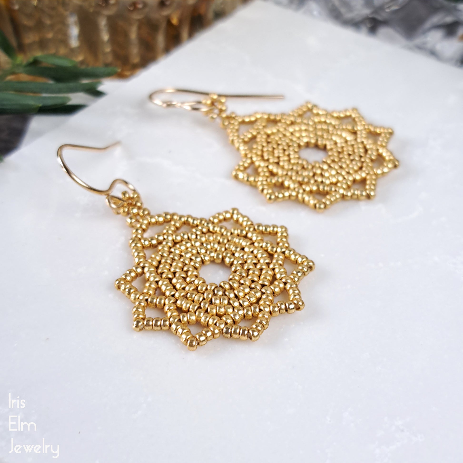 Gold beaded seed bead mandala earrings with gold-filled ear wires on a white surface with 'Iris Elm Jewelry' branding.