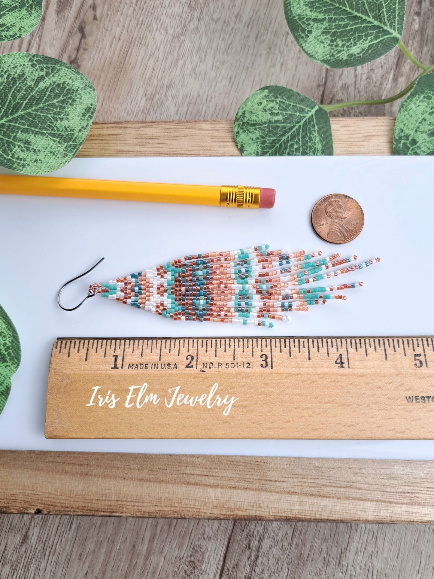 4.5 inch fringe earrings next to ruler, penny, and pencil for scale