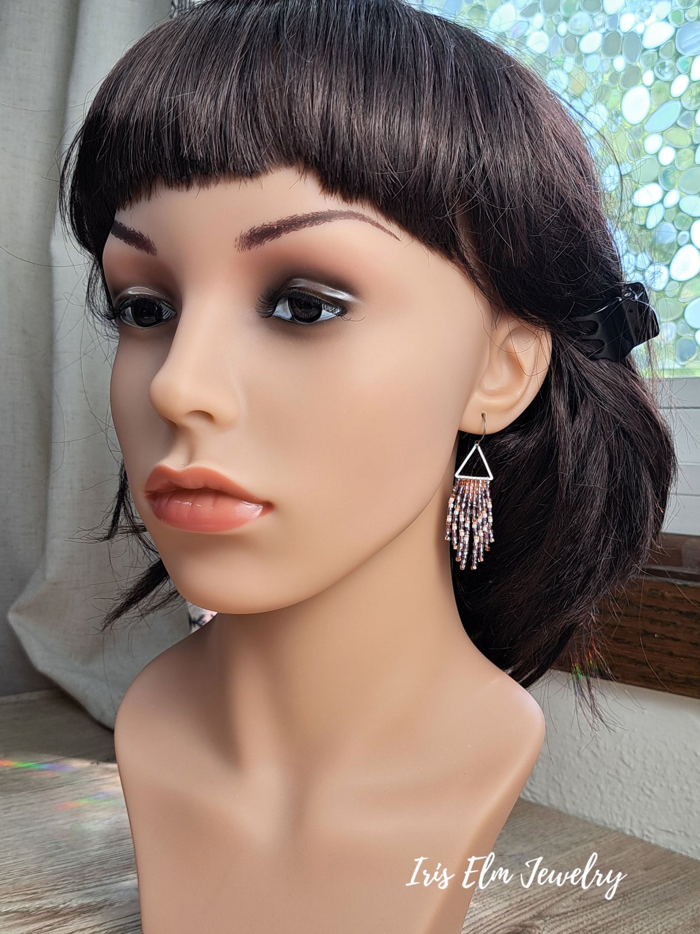 handmade small seed bead handwoven purple and copper orange seed bead fringe earrings on mannequin Iris Elm Jewelry branding.