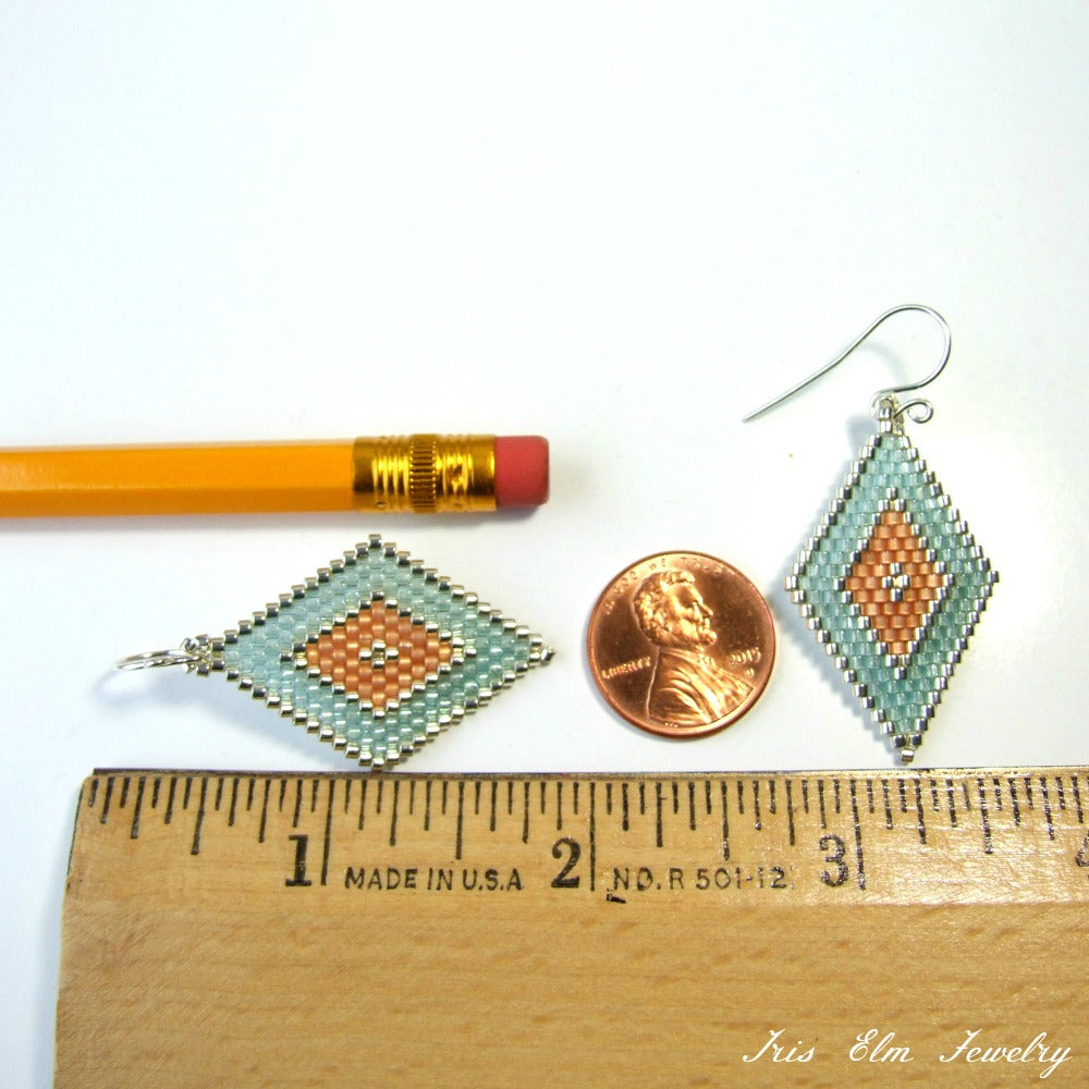 glass beaded earrings next to a pencil and penny for scale, with 'Iris Elm Jewelry' branding.