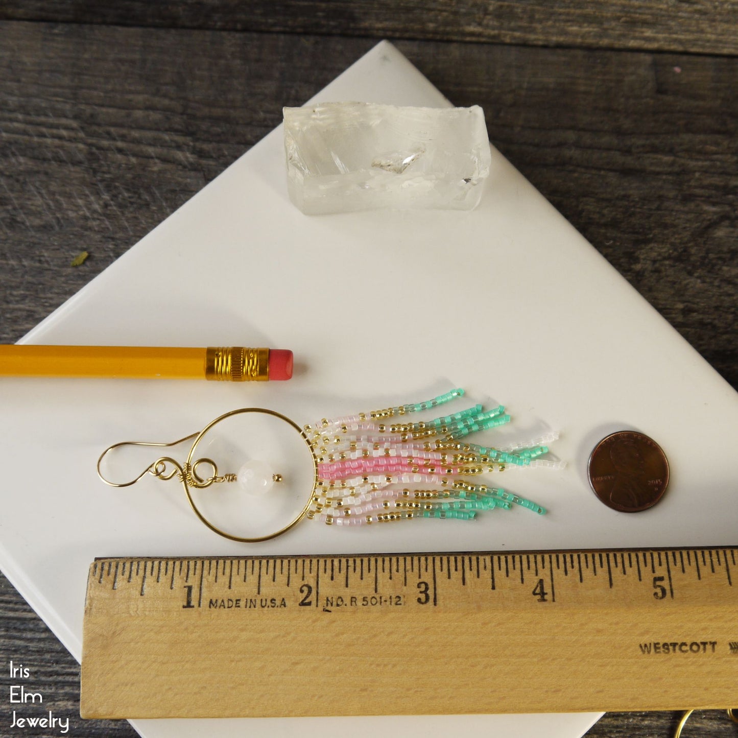 4.25 inch long fringe earrings with colorful beads on a white surface, ruler for scale, pencil, and coin.