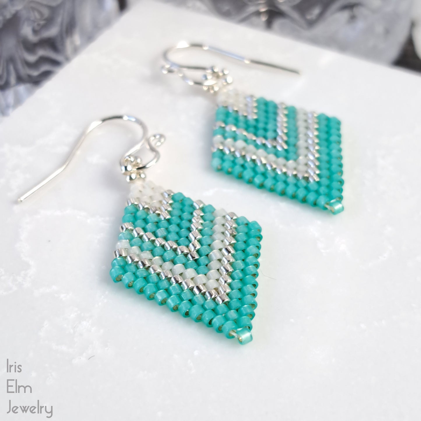 mint green, white, and silver chevron diamond seed bead glass earrings on a white surface with 'Iris Elm Jewelry' branding