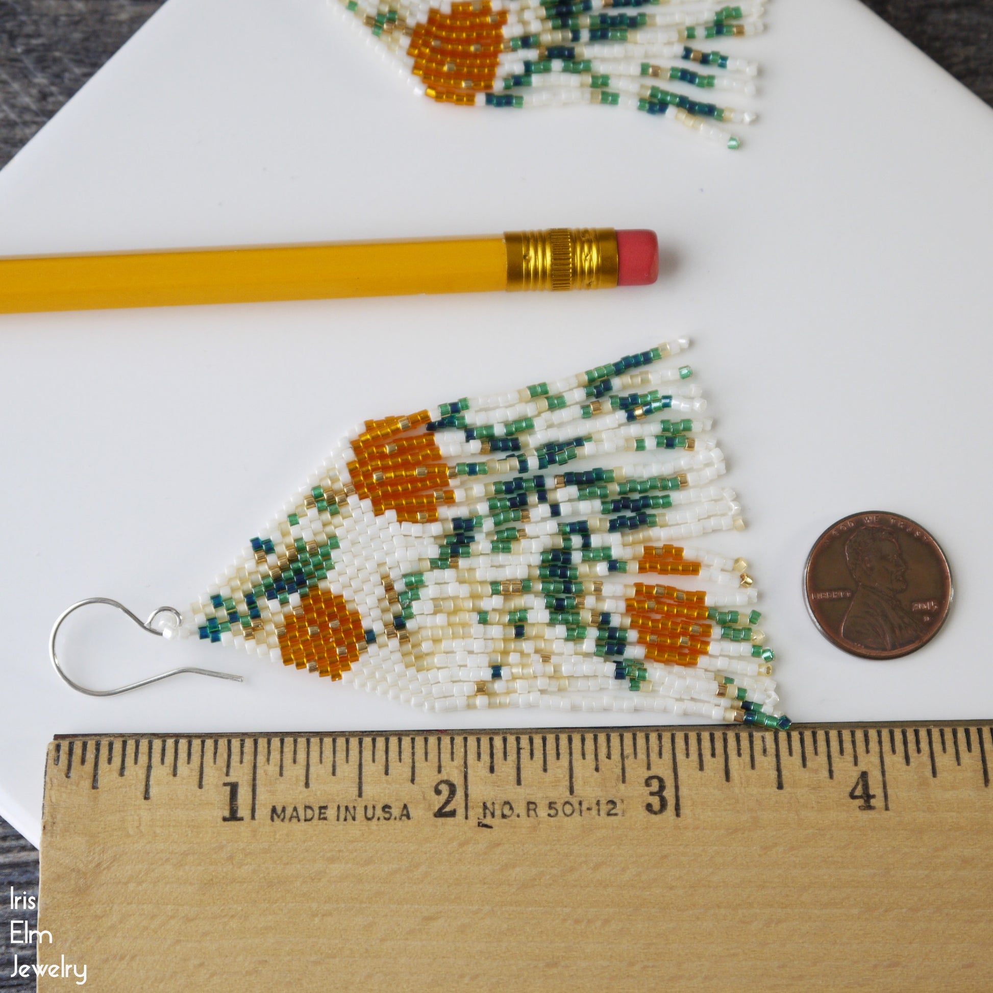 Beaded 3.5 inch long floral fringe earrings with a ruler for scale on a white surface