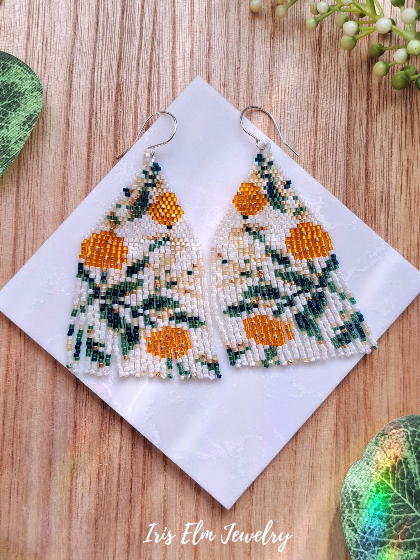 yellow orange flower fruit seed bead fringe earrings on marble tile