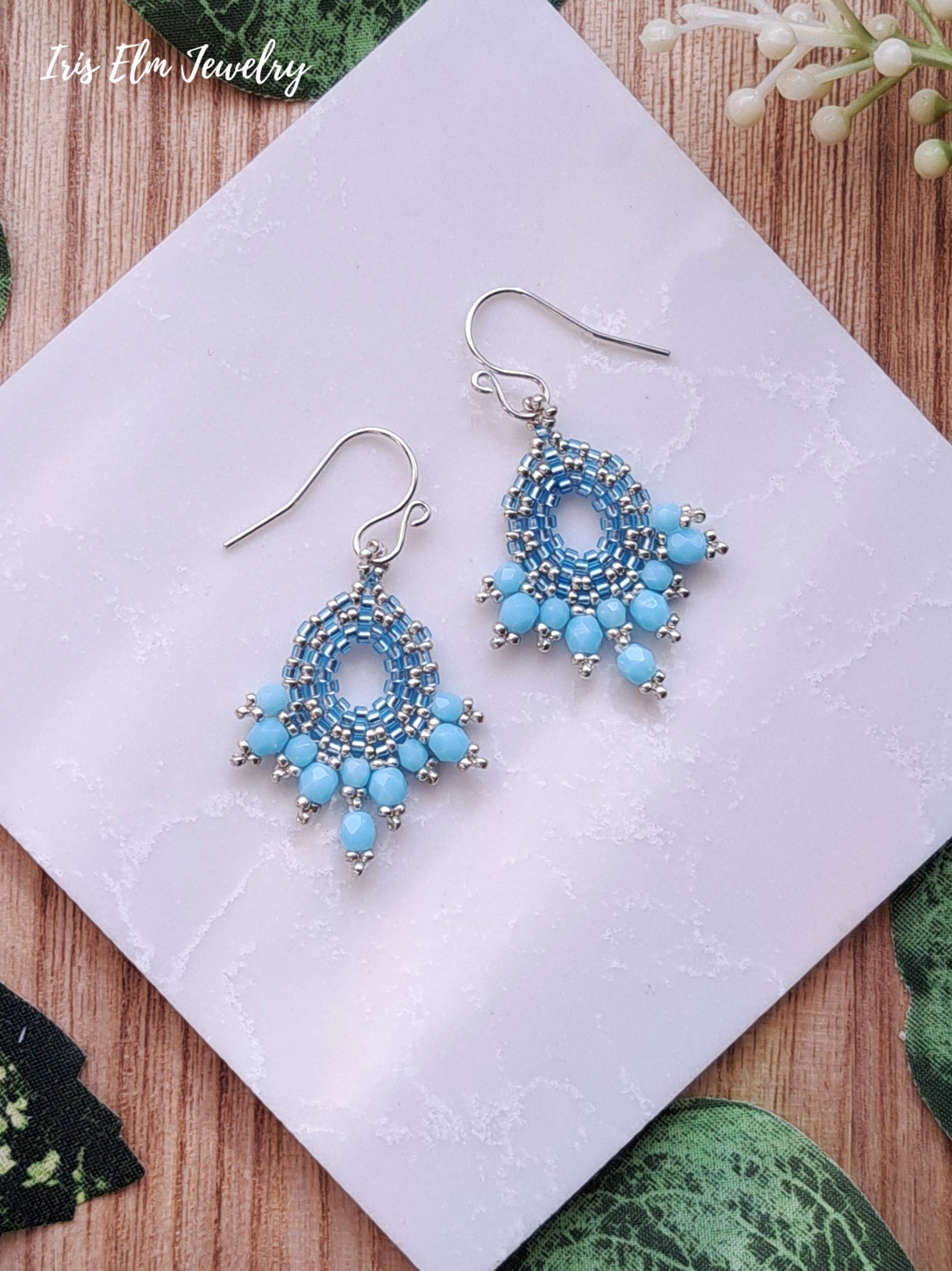 light Blue beaded glass handmade earrings on a white card with 'Iris Elm Jewelry' branding.