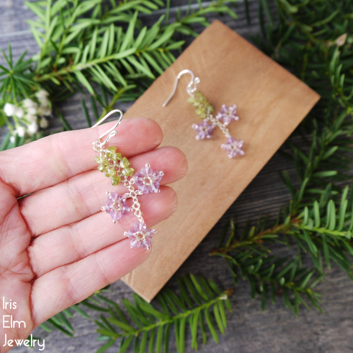 handmade Floral earrings held by a hand with a natural background