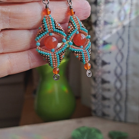 hand holding carnelian gemstone and seed bead beadwork earrings