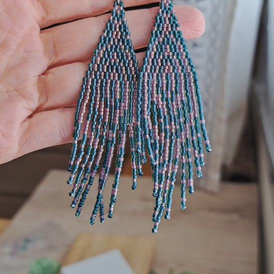 hand holding pair of forest green and pink seed bead fringe art deco earrings