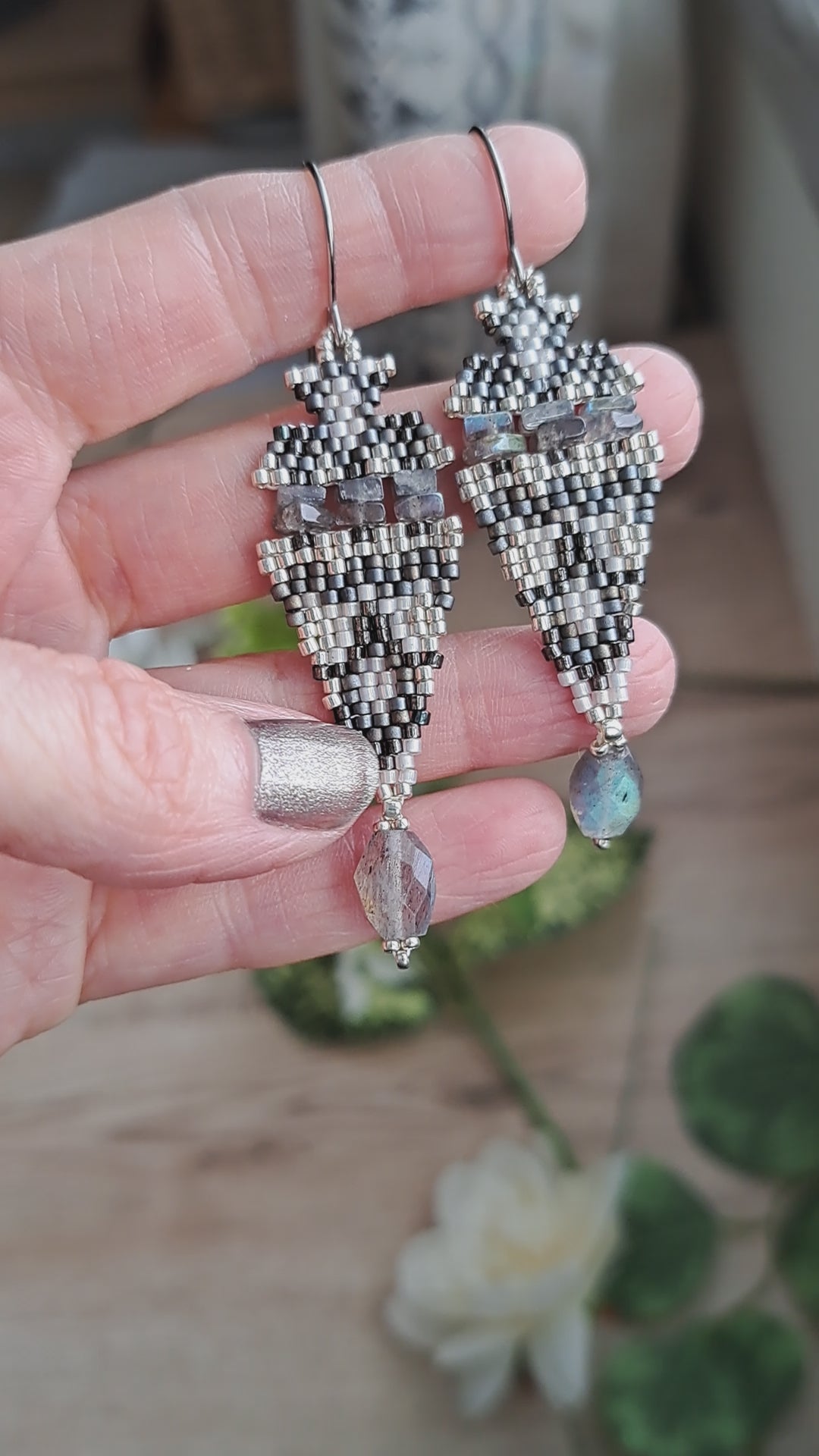 hand holding iridescent labradorite stone and seed bead boho beadwork earrings