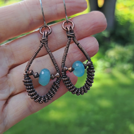 hand holding copper wire wrapped blue chalcedony handmade earrings