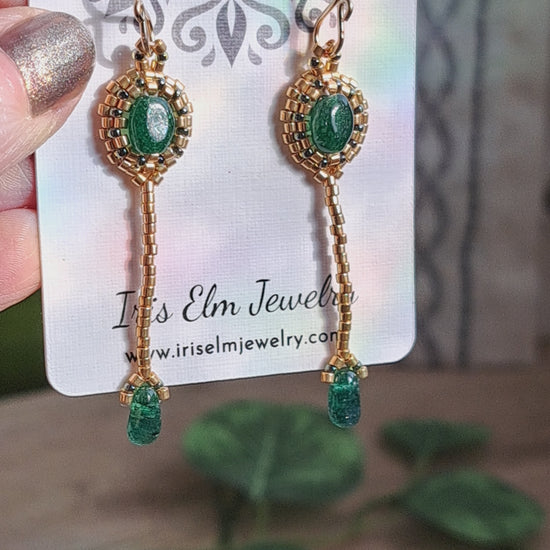 gold seed bead and green aventurine earrings on a Iris Elm Jewelry card held in hand