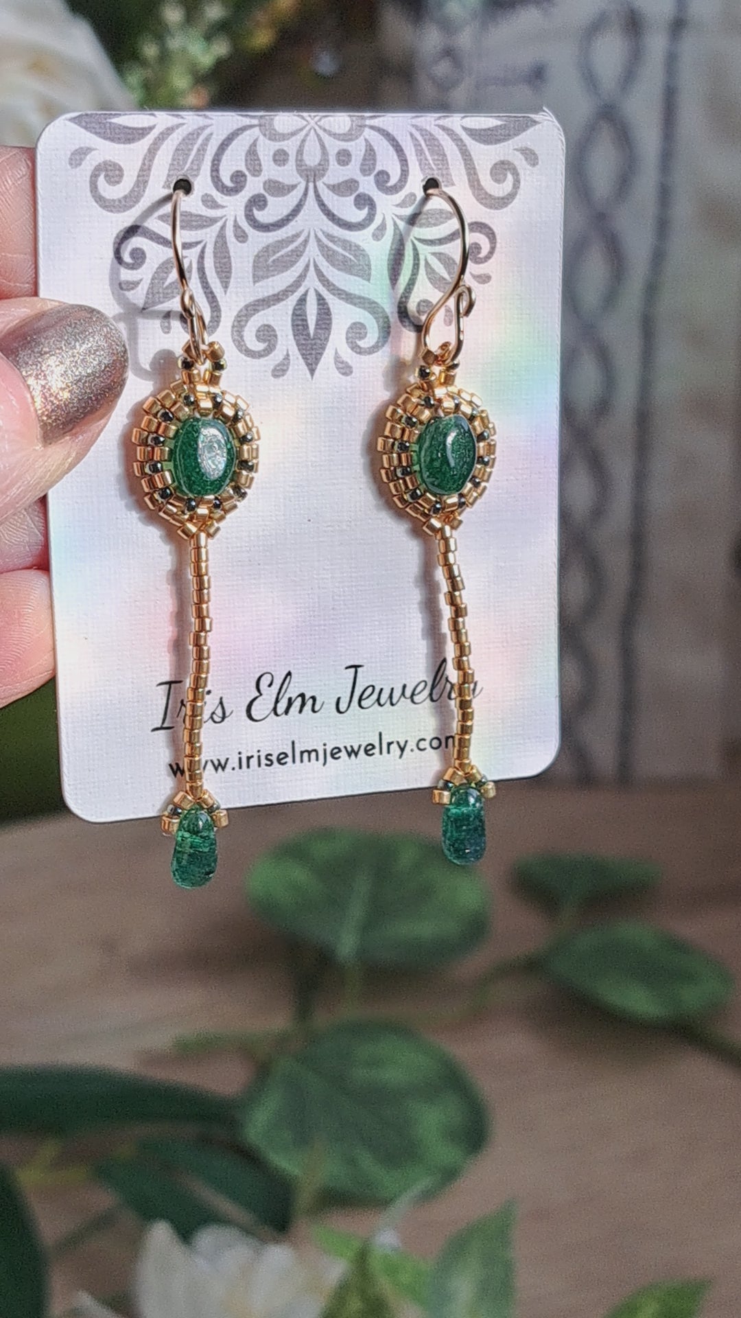 gold seed bead and green aventurine earrings on a Iris Elm Jewelry card held in hand