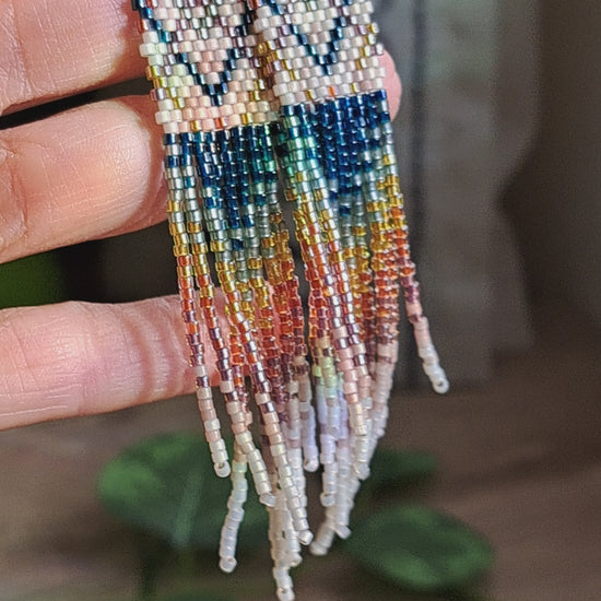 hand holding pair of plaid rainbow seed bead fringe earrings