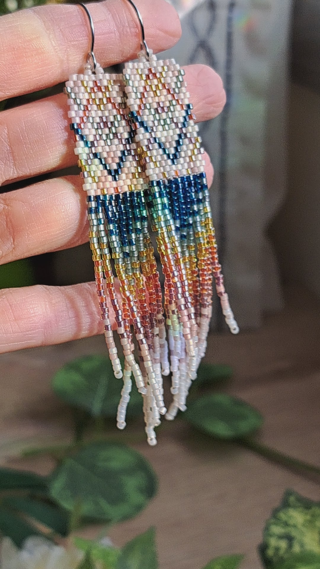 hand holding pair of plaid rainbow seed bead fringe earrings